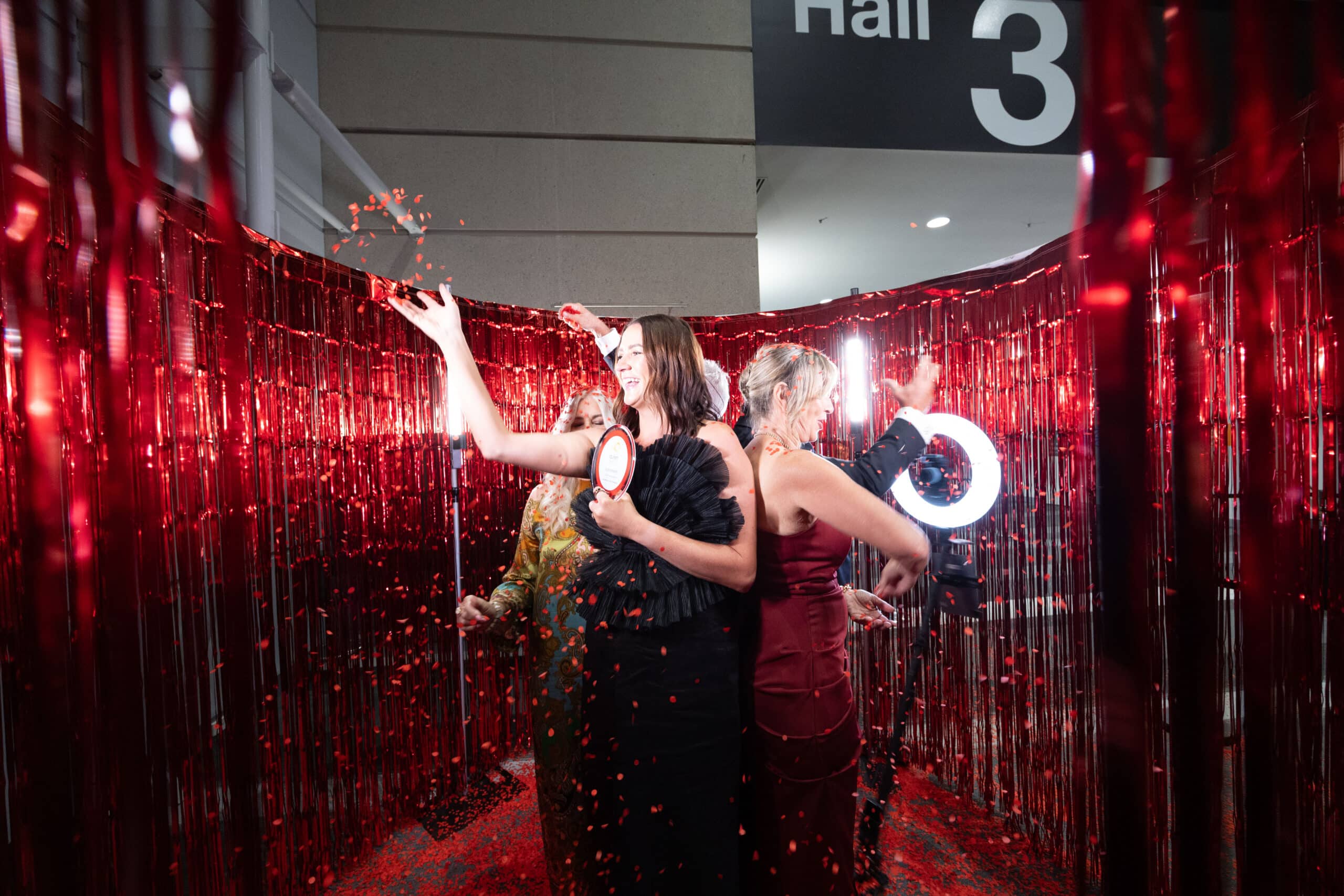 Guests using 360 video booth with red confetti at Queensland Tourism Awards Brisbane